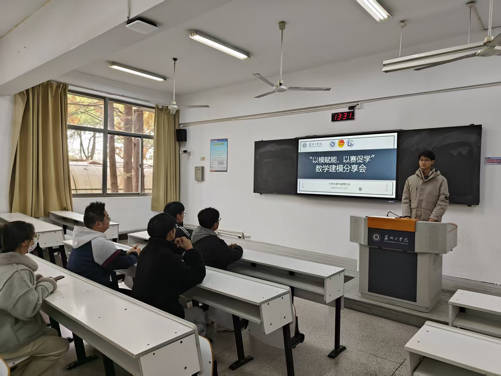 数学建模分享会现场，讲台上的同学分享经验，台下同学聆听