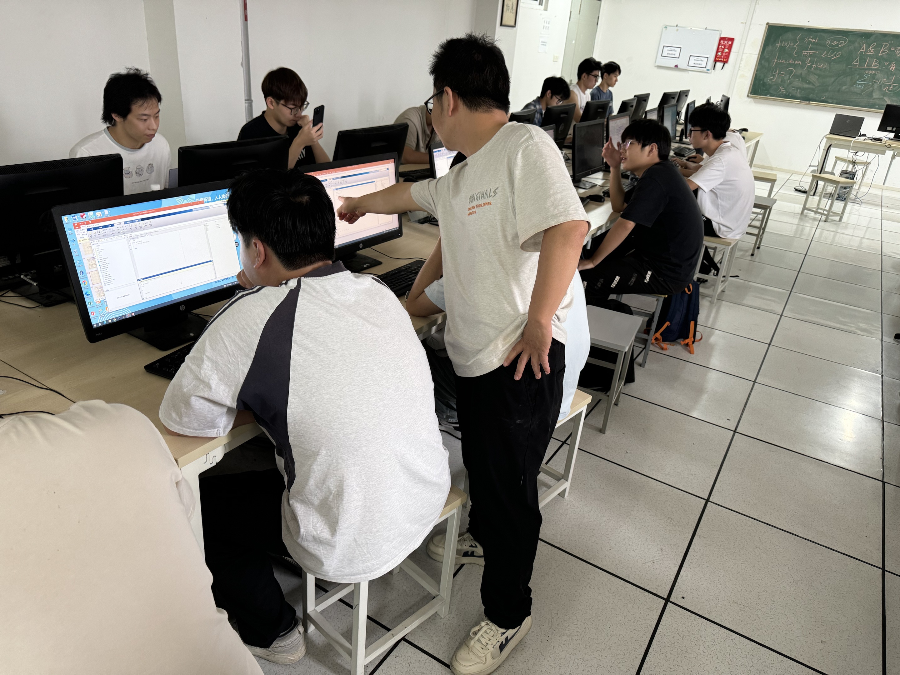 同学在电脑前交流操作和计算思路
